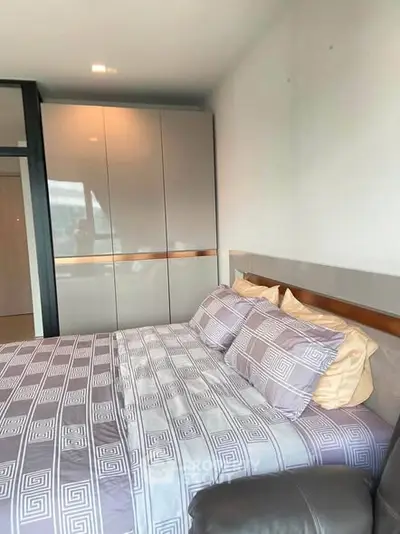 Modern bedroom with stylish bedding and sleek wardrobe design.