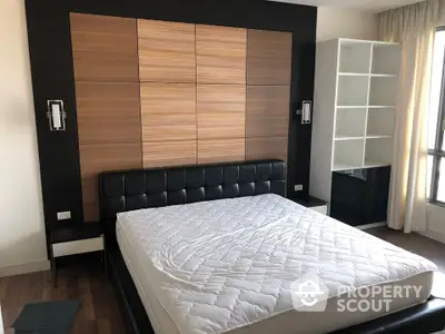 Modern bedroom with stylish wood paneling and large window for natural light.