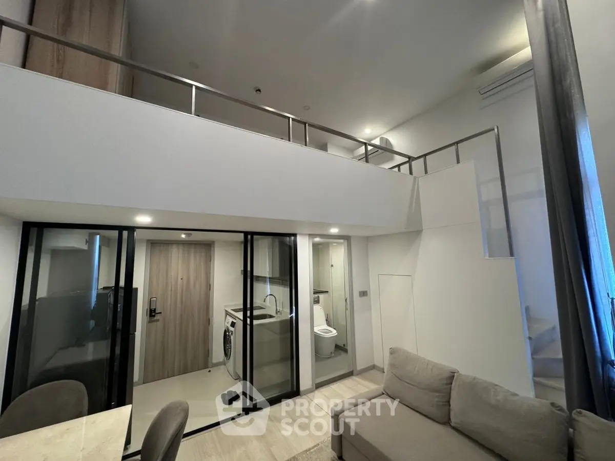 Modern loft apartment with mezzanine, stylish interior, and washing machine.