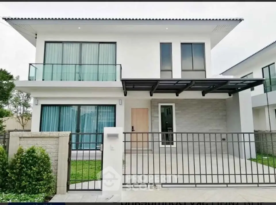 Modern two-story house with sleek design and spacious balcony in a serene neighborhood.