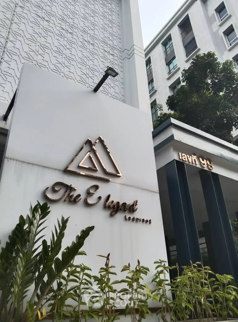 Modern building entrance with stylish signage and lush greenery