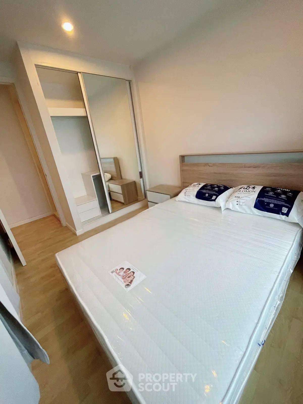 Modern bedroom with mirrored wardrobe and new mattress in stylish apartment