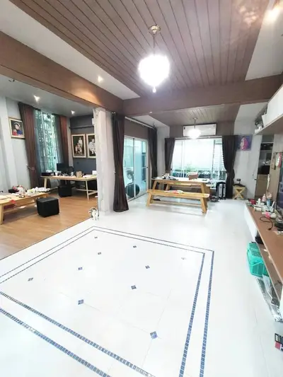 Spacious living room with wooden ceiling and large windows for natural light.