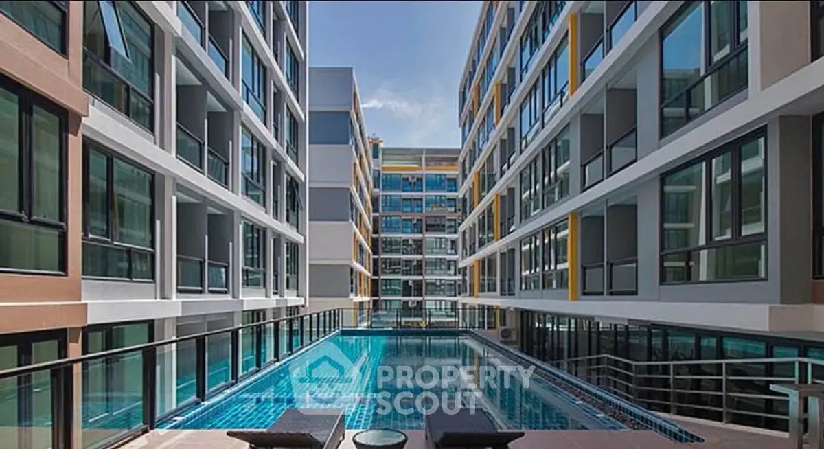 Modern apartment complex with a stunning pool and sleek architectural design.