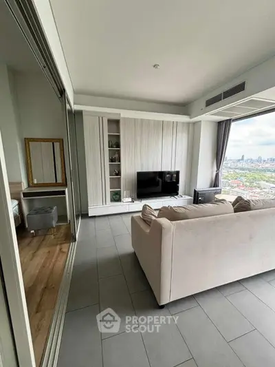 Modern living room with city view, featuring sleek furniture and large windows for natural light.