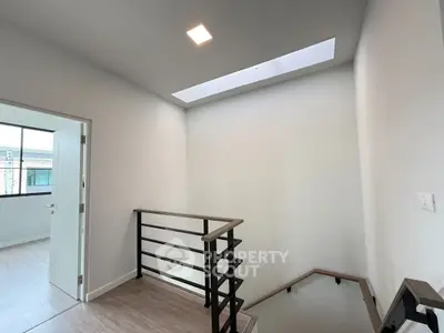 Modern stairway with sleek railing and skylight in contemporary home