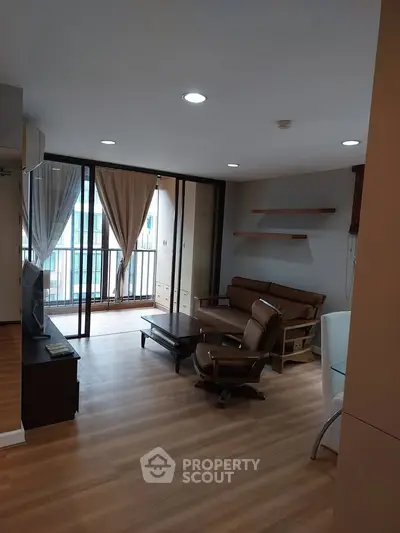 Spacious living room with modern furniture and balcony access in a stylish apartment.