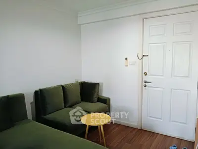 Cozy living room with green sofas and a wooden floor, perfect for relaxation.