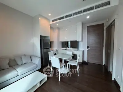 Modern open-plan living room and kitchen with sleek furniture and appliances