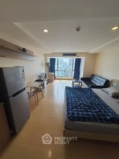 Modern studio apartment with city view, featuring a cozy bed, compact kitchen, and stylish living area.
