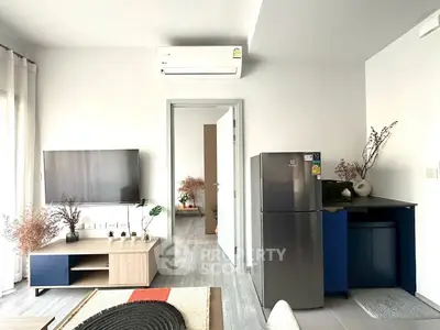 Modern living room with sleek design, featuring a wall-mounted TV, air conditioning, and stylish decor.