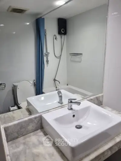 Modern bathroom with sleek sink and shower area in contemporary apartment