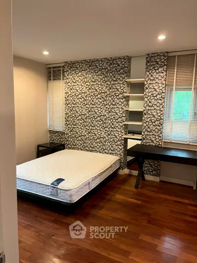 Cozy bedroom with stylish wallpaper and wooden flooring