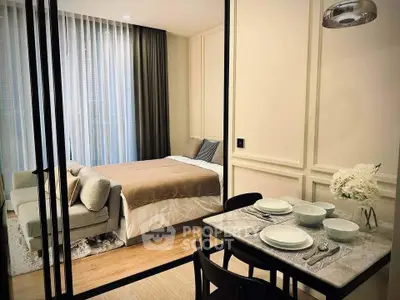Modern studio apartment with cozy bedroom and dining area, featuring elegant decor and natural light.