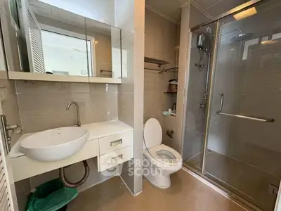Modern bathroom with glass shower and sleek fixtures in contemporary home.