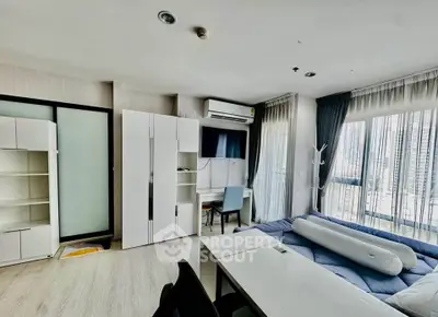 Modern studio apartment with large windows and stylish furnishings in a high-rise building.