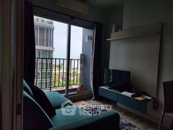 Modern living room with balcony and city view, featuring sleek furniture and natural light.