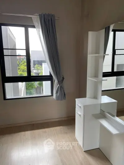 Bright bedroom with large windows and modern white furniture