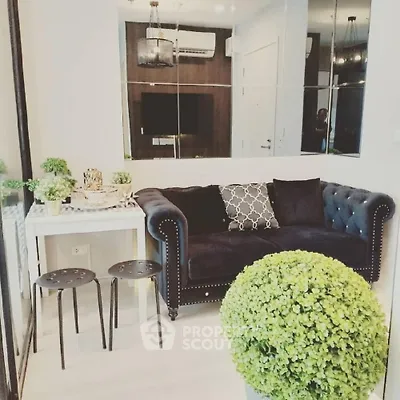 Chic living room with plush sofa, stylish decor, and modern lighting in a cozy apartment setting.