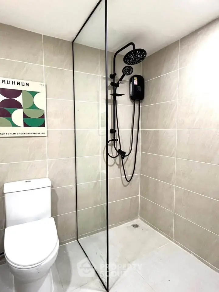 Modern bathroom with sleek shower and toilet in minimalist design.