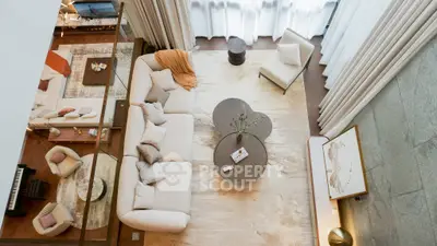 Luxurious living room with elegant decor, plush seating, and natural light from large windows.