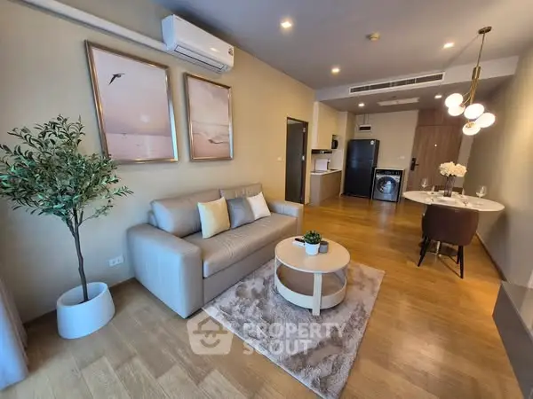 Modern living room with elegant decor and open layout, featuring a cozy sofa and stylish dining area.