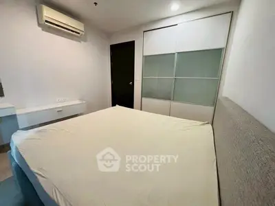 Cozy bedroom with modern air conditioning and sliding closet doors in a stylish apartment.