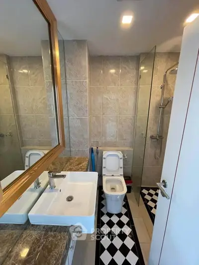 Modern bathroom with elegant fixtures and glass shower enclosure in a stylish apartment.