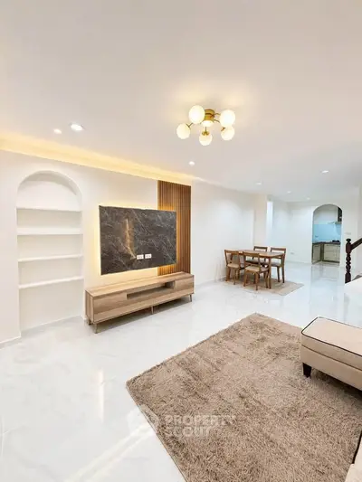Spacious modern living room with elegant lighting and open dining area