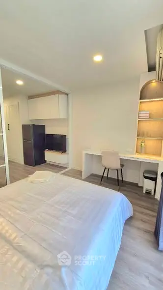 Modern bedroom with study area and sleek furniture in a stylish apartment.