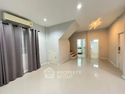 Spacious modern living room with staircase and sleek tile flooring