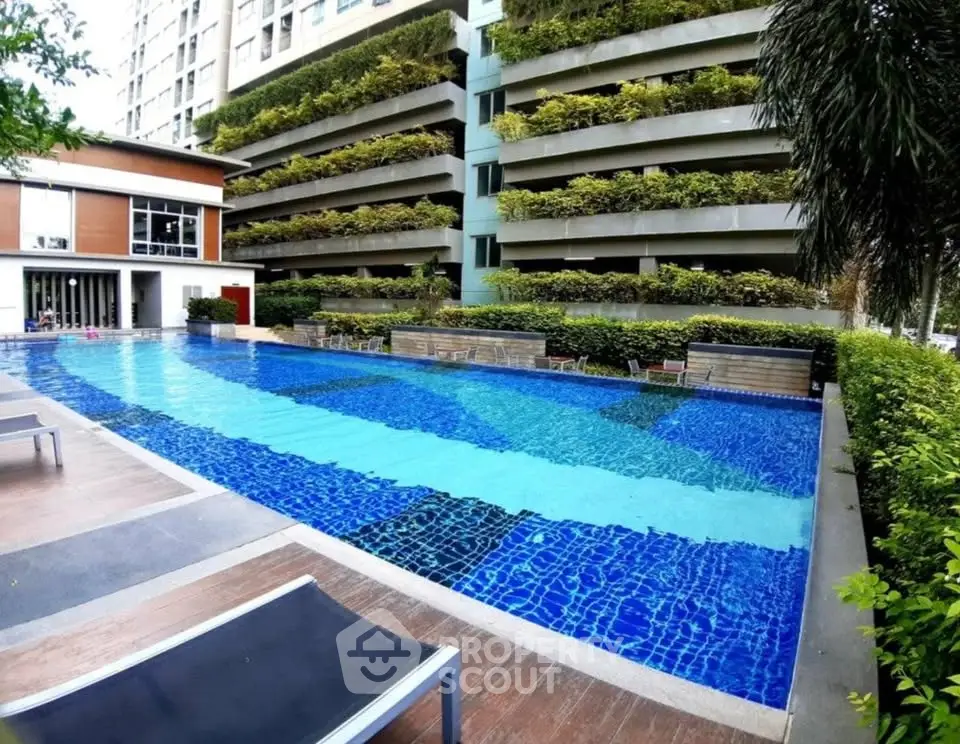 Luxurious condominium pool area with modern design and lush greenery