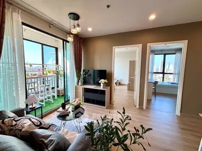 Modern living room with balcony and city view, featuring stylish decor and natural light.