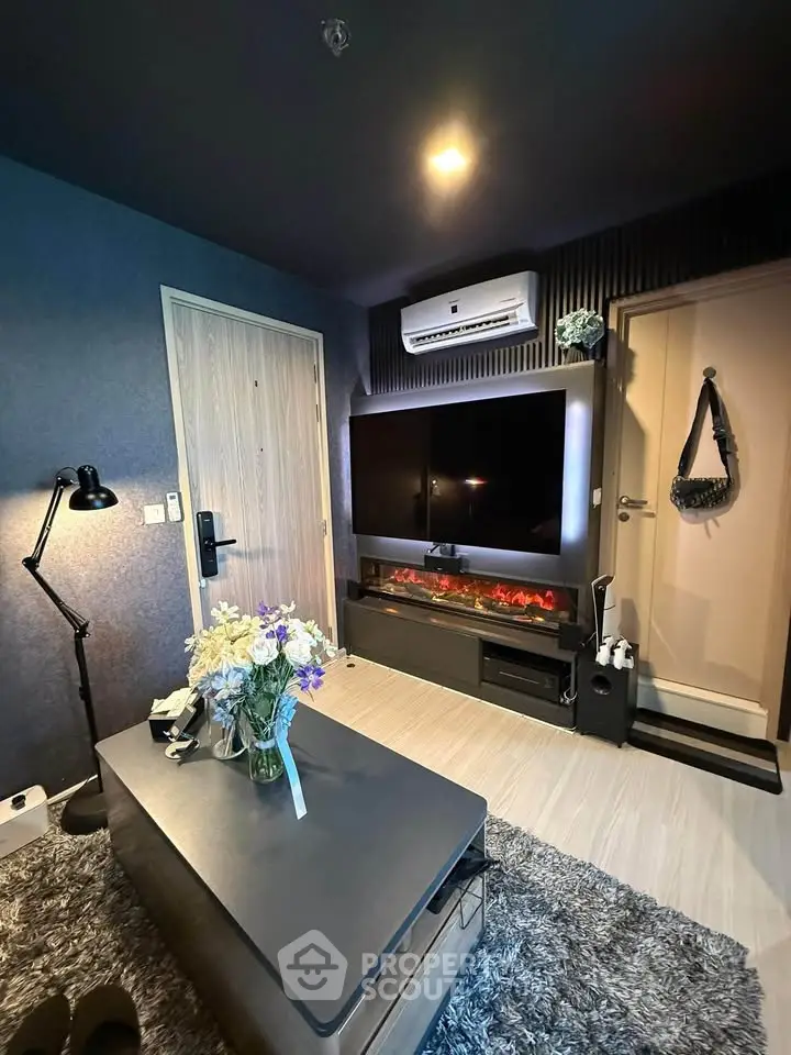 Modern living room with stylish decor, featuring a large TV, air conditioning, and cozy lighting.