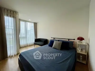 Cozy bedroom with modern decor and large window for natural light.