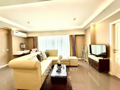 Spacious modern living room with elegant beige sofa and large window, perfect for relaxation.