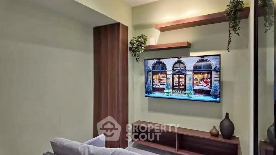 Modern living room with wall-mounted TV and stylish wooden shelves.