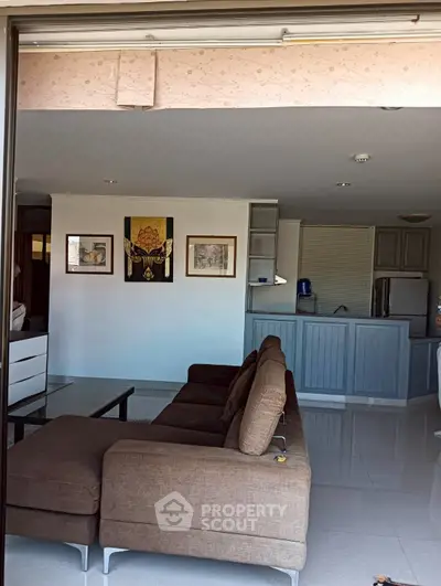 Spacious living room with modern kitchen and stylish decor in open layout apartment.