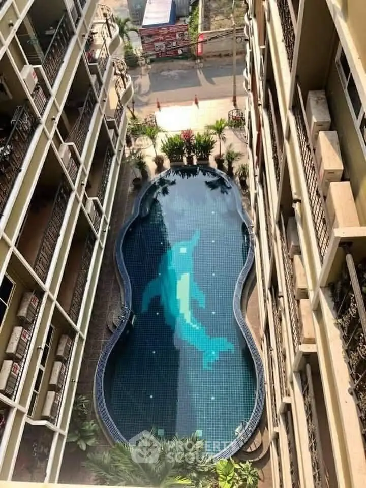 Stunning aerial view of a unique dolphin-themed swimming pool in a modern apartment complex.