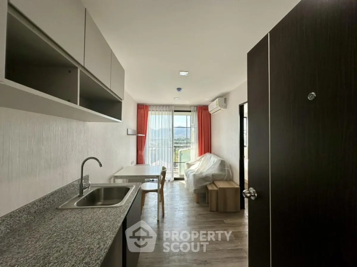 Modern apartment interior with open kitchen and scenic balcony view