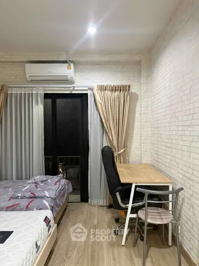 Cozy bedroom with study area, featuring a bed, desk, and air conditioning, perfect for comfortable living.