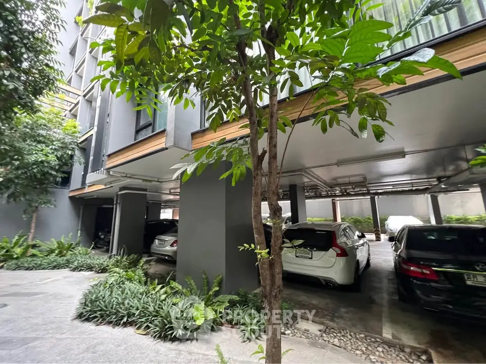 Modern residential building with covered parking and lush greenery