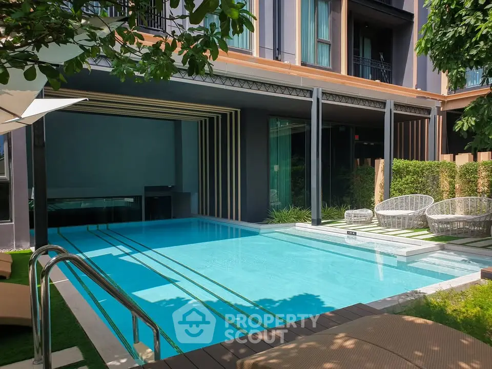 Luxurious outdoor pool area with modern design and stylish seating in a high-end residential complex.