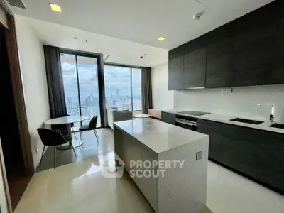 Modern kitchen with island and stunning city view from large windows.