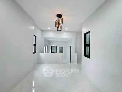 Spacious modern interior with elegant lighting and sleek white flooring, perfect for contemporary living.