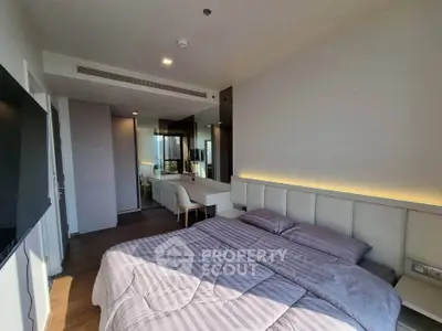 Modern bedroom with stylish decor and ample natural light, featuring a cozy bed and sleek furniture.
