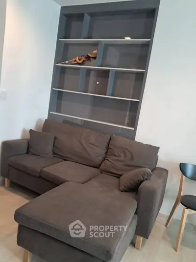 Modern living room with stylish gray sofa and built-in shelving