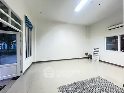 Spacious interior with large windows and modern flooring, perfect for versatile living or office space.