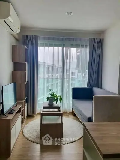 Modern living room with natural light, featuring a cozy sofa, TV, and stylish decor.