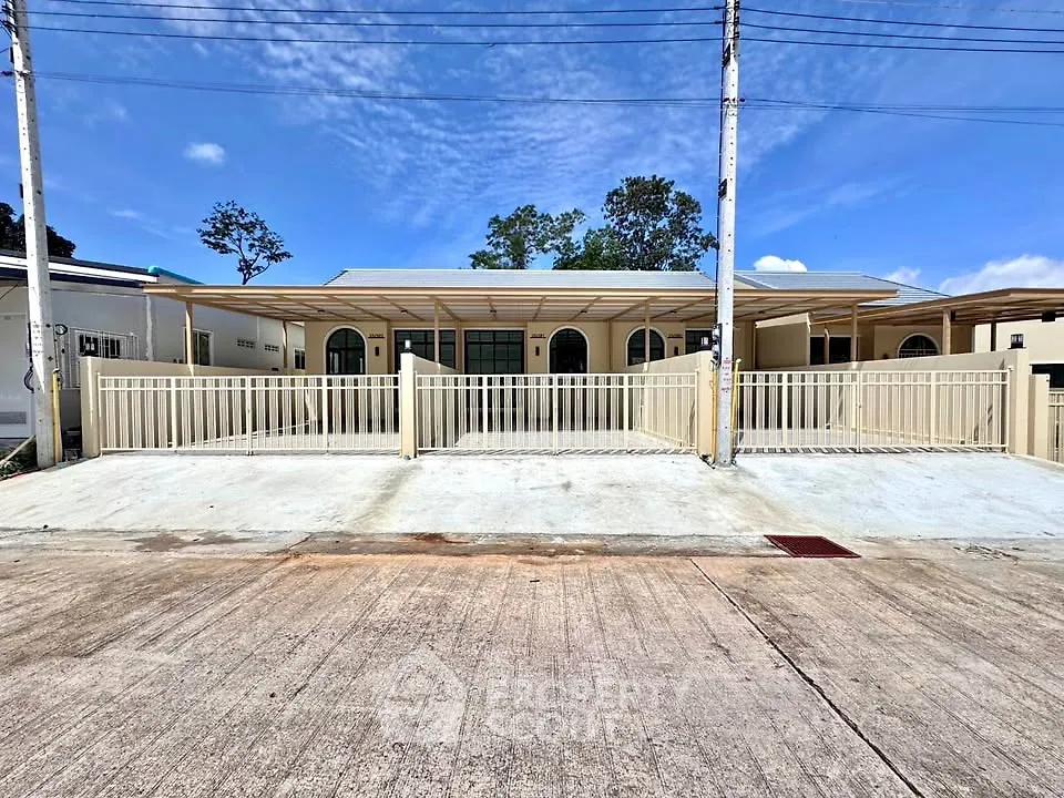Modern single-story house with spacious driveway and gated entrance